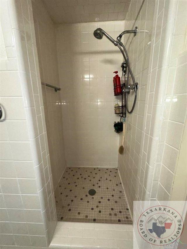 bathroom with a tile shower and tile patterned floors