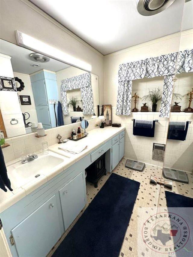 bathroom with tile patterned flooring, vanity, and tile walls