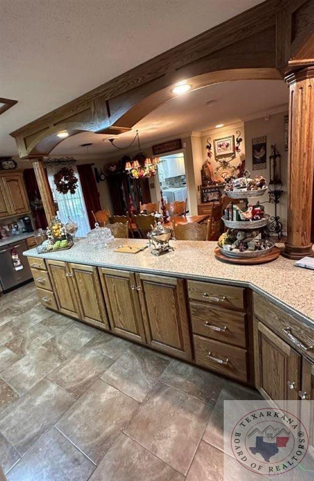 kitchen featuring decorative columns and crown molding