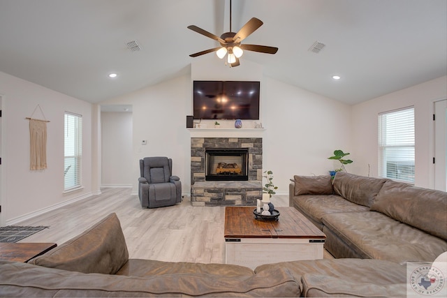 living room featuring light wood-type flooring, ceiling fan, a fireplace, and lofted ceiling