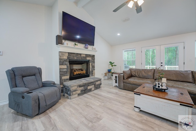 living room with french doors, a fireplace, light hardwood / wood-style floors, lofted ceiling with beams, and ceiling fan