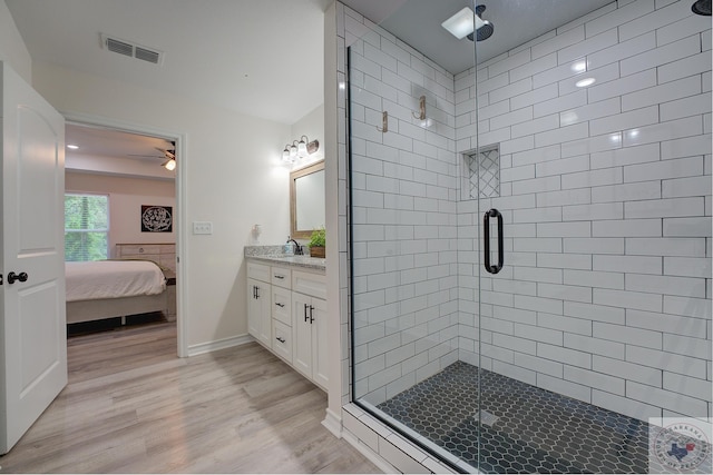 bathroom featuring wood-type flooring, an enclosed shower, ceiling fan, and vanity