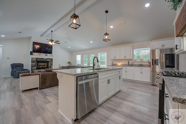 kitchen featuring sink, a center island with sink, white cabinetry, and appliances with stainless steel finishes