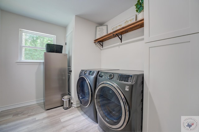 laundry room featuring washer and dryer and light wood-type flooring