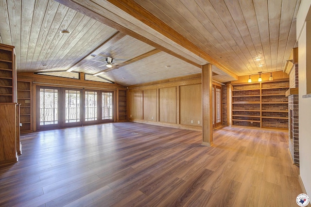 unfurnished living room with ceiling fan, built in shelves, wood finished floors, wooden ceiling, and lofted ceiling with beams
