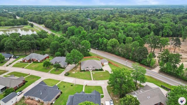 drone / aerial view featuring a residential view, a water view, and a forest view