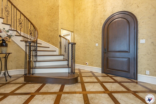foyer entrance featuring baseboards and stairway