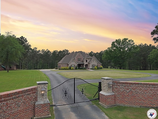 exterior space with a lawn, a chimney, and aphalt driveway
