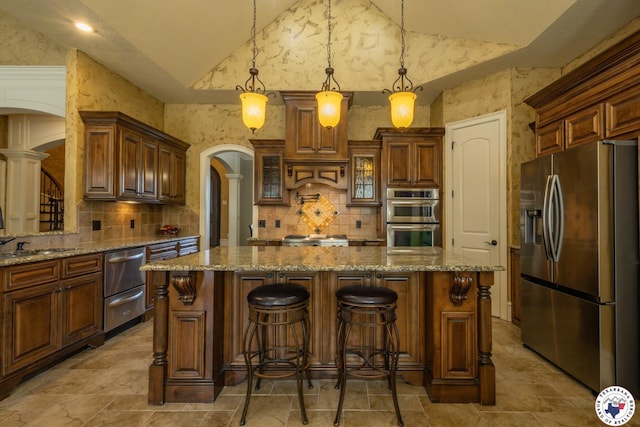 kitchen with decorative backsplash, decorative columns, arched walkways, appliances with stainless steel finishes, and vaulted ceiling