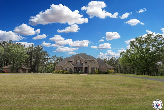 view of front of home featuring a front lawn and stone siding