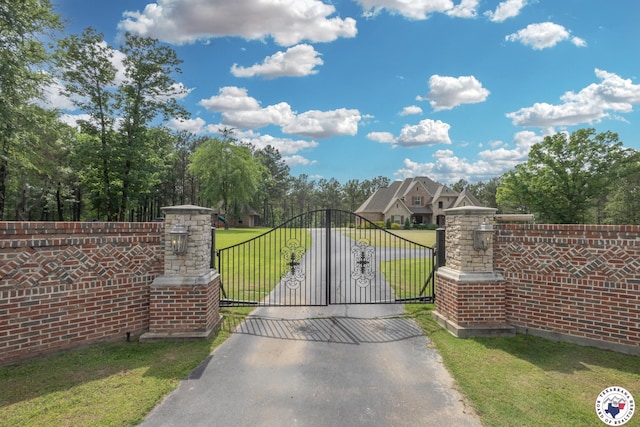 view of gate with a yard