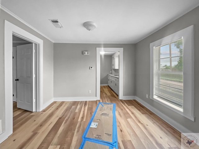 unfurnished room with crown molding and light hardwood / wood-style floors