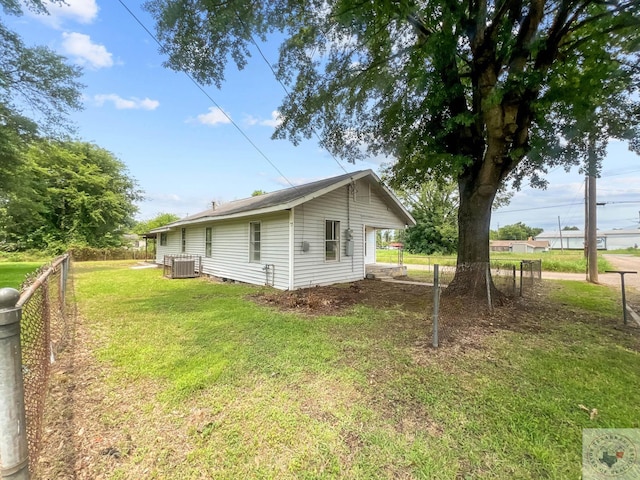 view of home's exterior featuring central AC unit and a yard