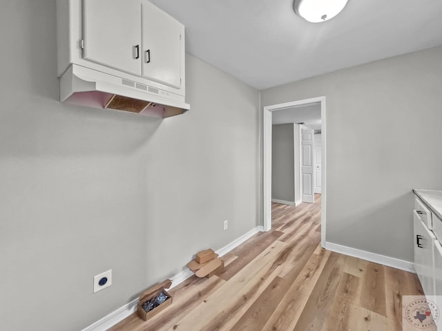 interior space featuring electric dryer hookup and light hardwood / wood-style floors