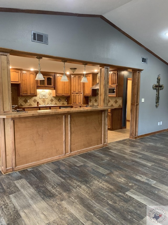 kitchen with decorative backsplash, dark wood-type flooring, pendant lighting, and crown molding