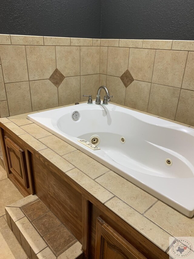 bathroom featuring a relaxing tiled tub and tile patterned flooring