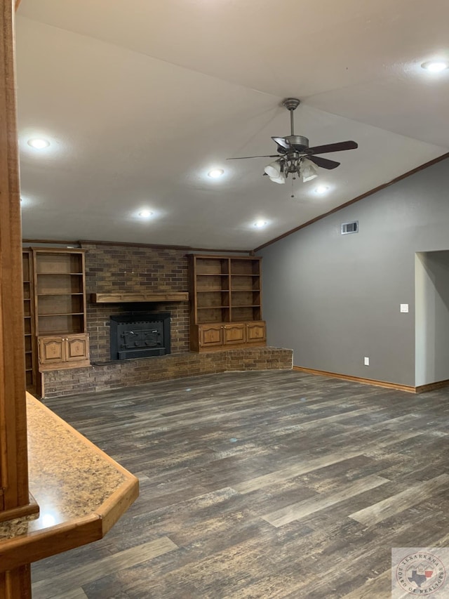 unfurnished living room featuring crown molding, a brick fireplace, dark hardwood / wood-style flooring, built in features, and ceiling fan