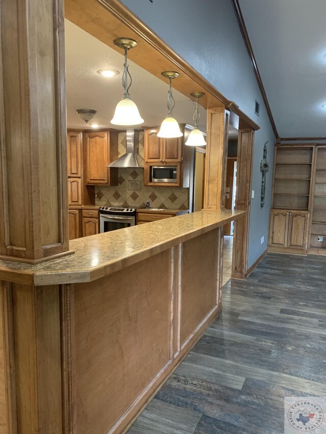 kitchen featuring hanging light fixtures, appliances with stainless steel finishes, wall chimney exhaust hood, dark hardwood / wood-style floors, and decorative backsplash