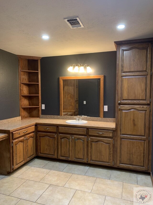 bathroom featuring built in features, tile patterned flooring, and vanity