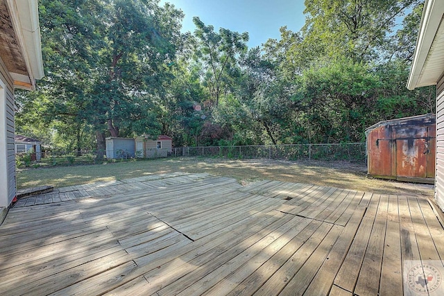 wooden deck with a lawn and a storage shed