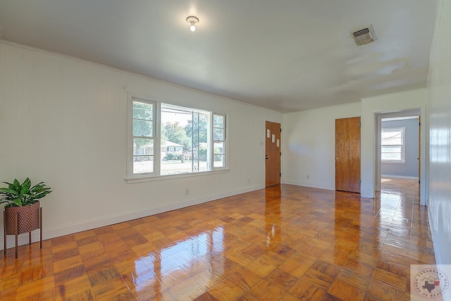 spare room featuring parquet flooring and a wealth of natural light