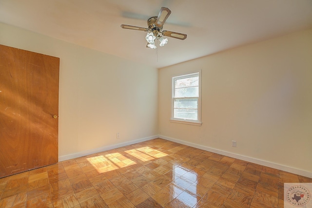 empty room with ceiling fan and light parquet floors