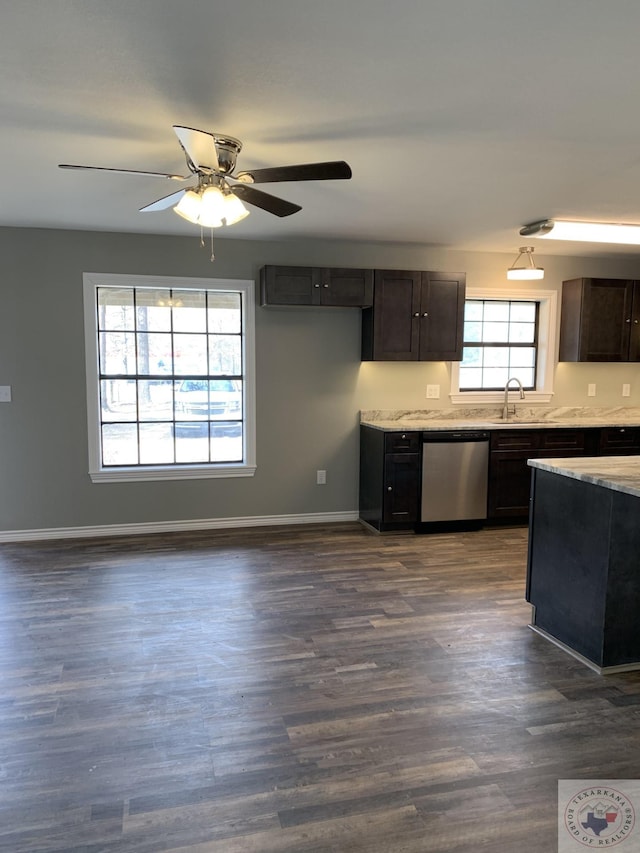 kitchen featuring sink, dark brown cabinetry, stainless steel dishwasher, and dark hardwood / wood-style flooring