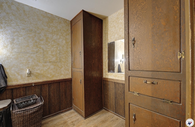 room details with a wainscoted wall, wood finished floors, and wooden walls