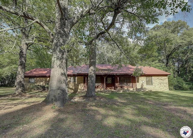 ranch-style home featuring a front yard and metal roof