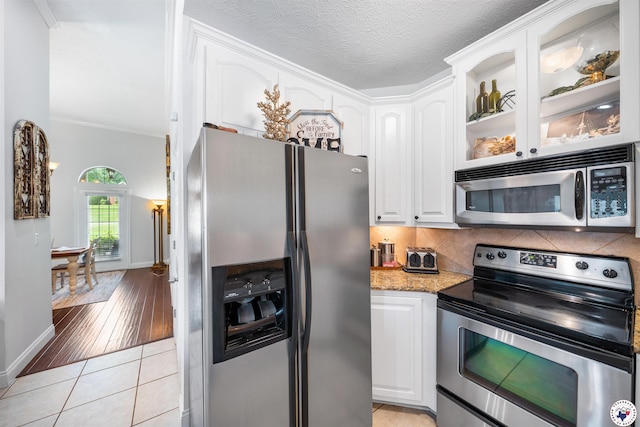 215 Hunters Cv, Texarkana, TX 75503 - kitchen featuring stainless steel appliances, white cabinets, tasteful backsplash, glass insert cabinets, and ornamental molding
