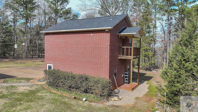 view of side of property featuring a balcony and a yard