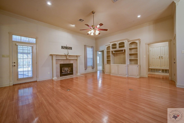 unfurnished living room featuring light hardwood / wood-style flooring, crown molding, and a fireplace