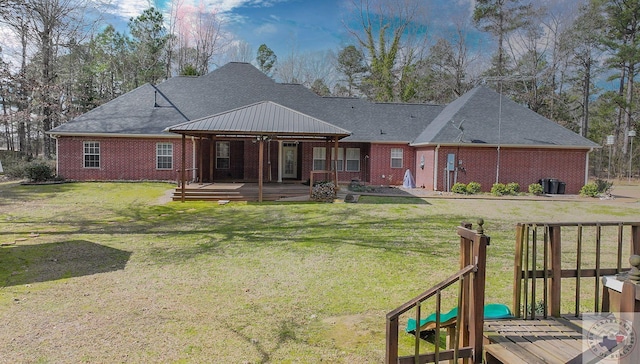 rear view of house featuring a deck and a lawn