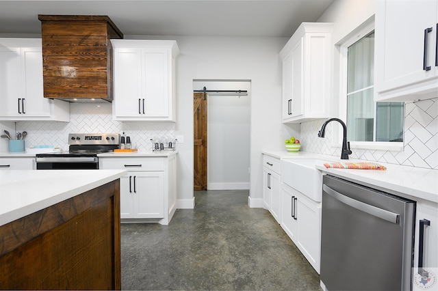 kitchen featuring sink, white cabinetry, stainless steel appliances, and a barn door