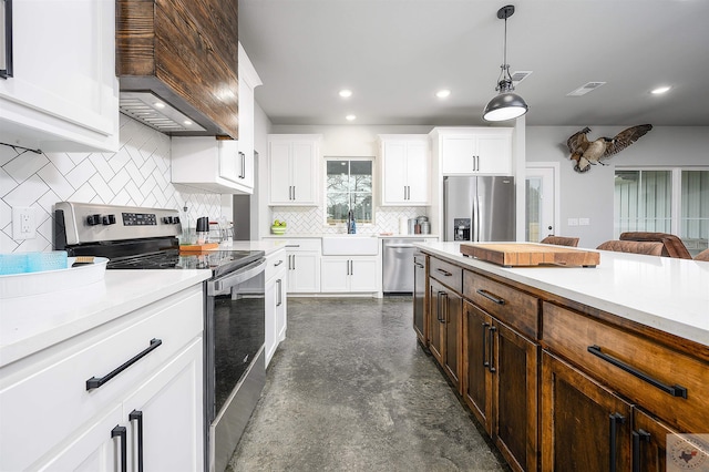 kitchen with sink, white cabinetry, stainless steel appliances, and custom range hood