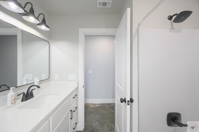 bathroom with a shower, concrete flooring, and vanity