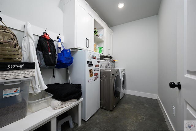 clothes washing area with cabinets and washer and clothes dryer