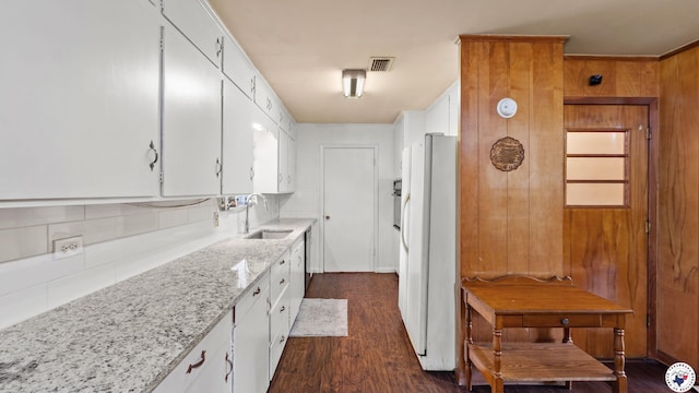 119 Hall St, New Boston, TX 75570 - kitchen featuring a sink, freestanding refrigerator, tasteful backsplash, white cabinetry, and wood walls