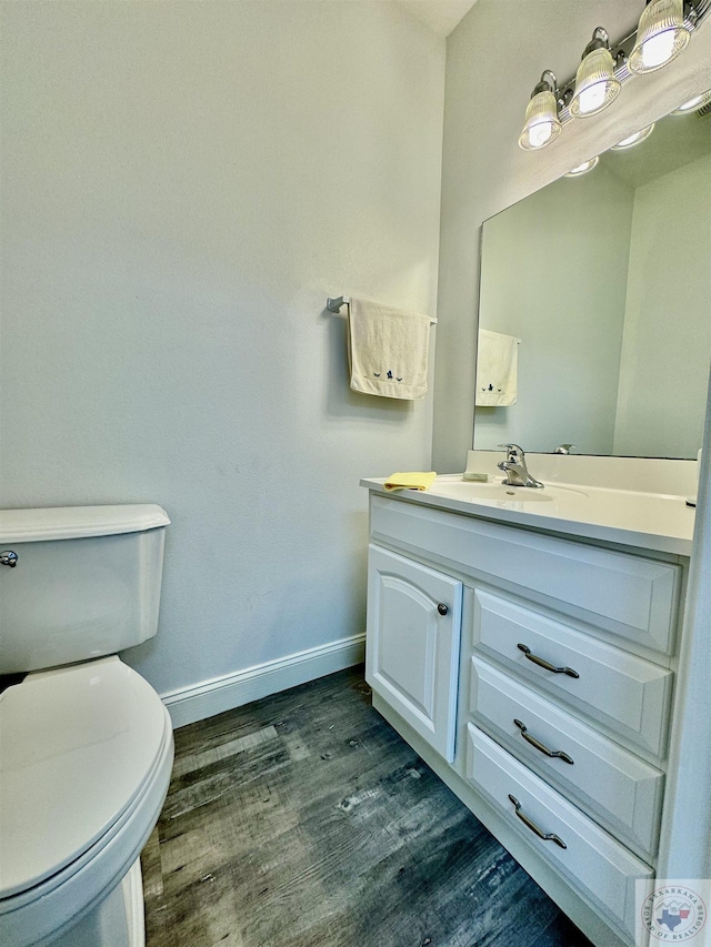 bathroom featuring vanity, toilet, and hardwood / wood-style flooring