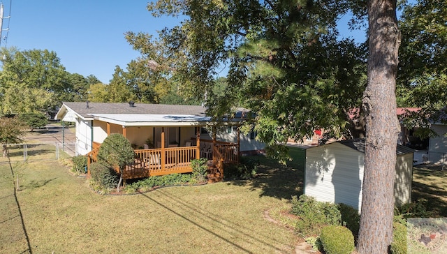 back of house featuring a deck and a lawn