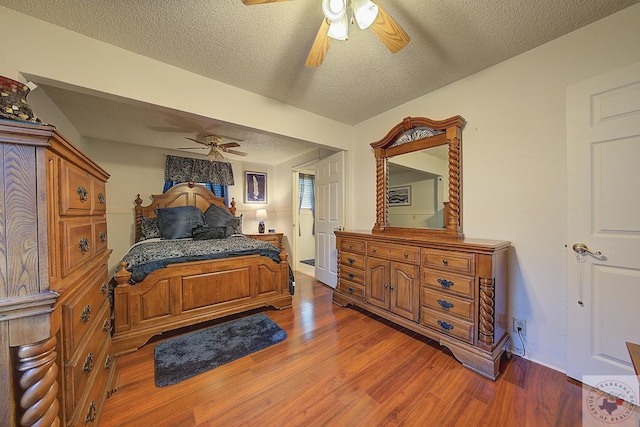 bedroom featuring ceiling fan, dark wood-type flooring, and a textured ceiling