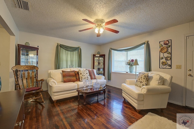 living room featuring a textured ceiling, dark hardwood / wood-style floors, and ceiling fan