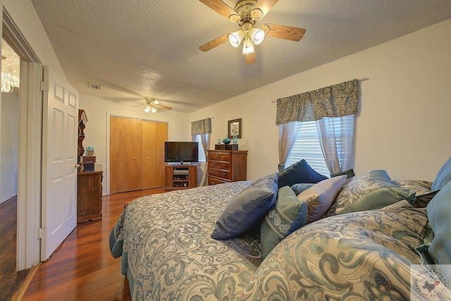 bedroom featuring dark hardwood / wood-style floors, a textured ceiling, a closet, and ceiling fan