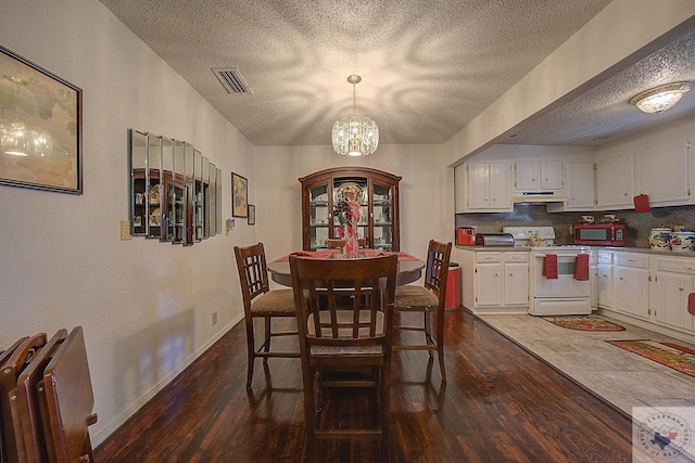 dining space with an inviting chandelier and dark hardwood / wood-style flooring