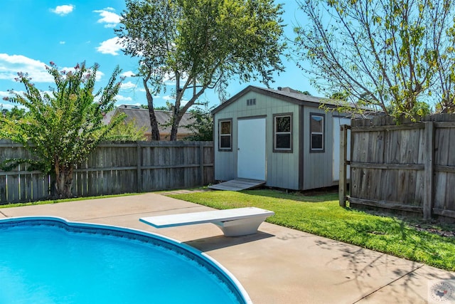 view of pool featuring a lawn, a storage unit, a diving board, and a patio