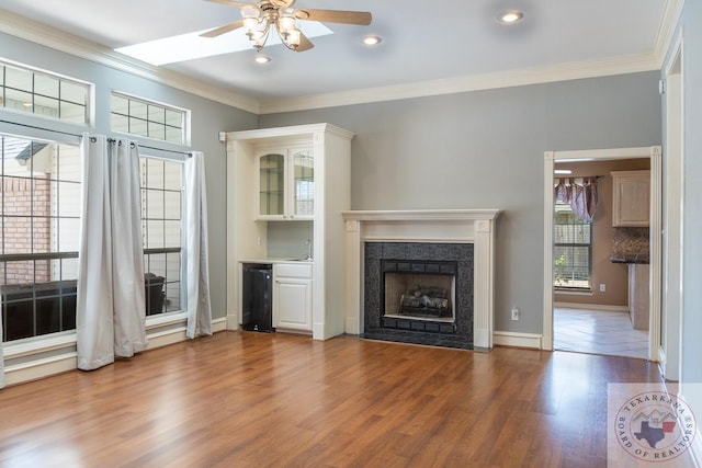 unfurnished living room with plenty of natural light, hardwood / wood-style floors, and ornamental molding