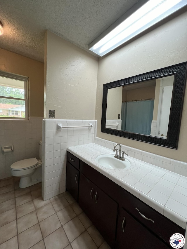 6 Arnold Dr, Texarkana, AR 71854 - full bathroom featuring tile patterned flooring, a textured ceiling, tile walls, vanity, and toilet