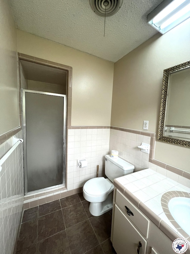 6 Arnold Dr, Texarkana, AR 71854 - full bathroom featuring tile walls, a shower stall, vanity, toilet, and wainscoting