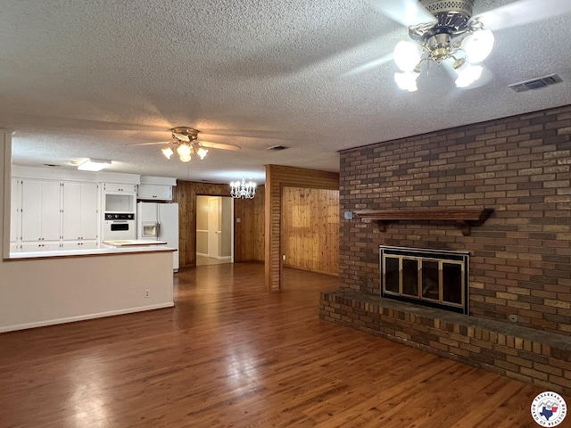 6 Arnold Dr, Texarkana, AR 71854 - unfurnished living room with a ceiling fan, a textured ceiling, dark wood-style floors, baseboards, and a fireplace