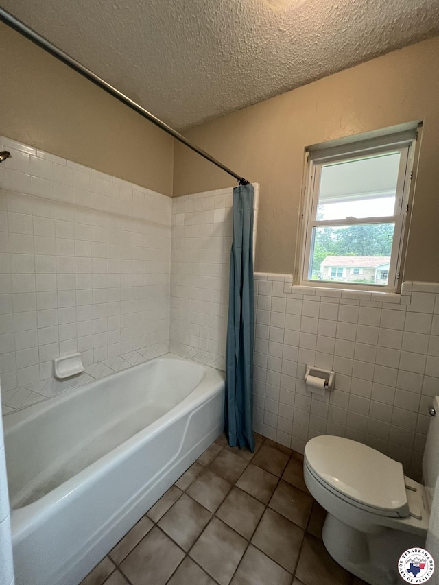 6 Arnold Dr, Texarkana, AR 71854 - full bath featuring tile walls, tile patterned flooring, toilet, a textured ceiling, and wainscoting
